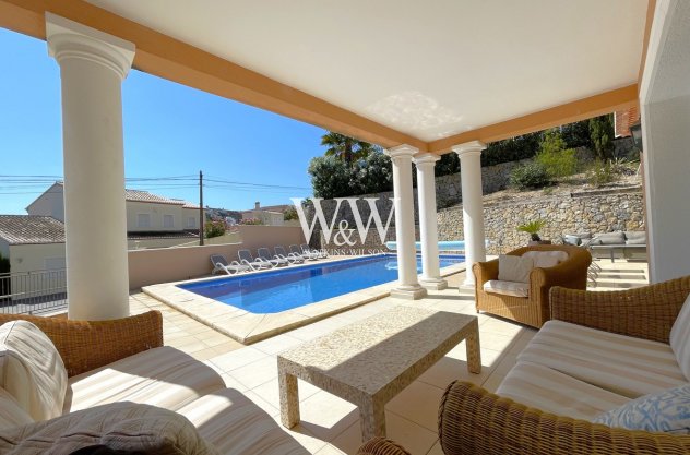 Terraza exterior cubierta con vista a la piscina.